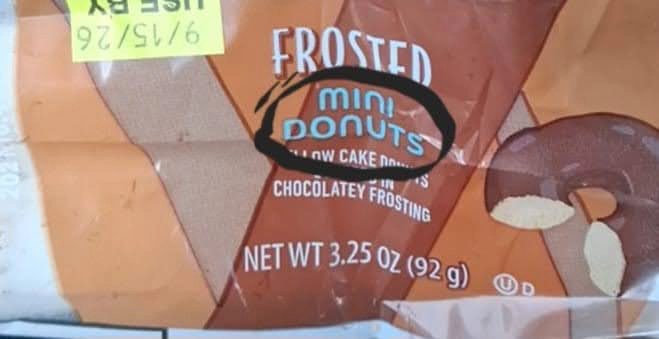 A bag of frosted mini donuts labeled mini, net weight 3.25 oz